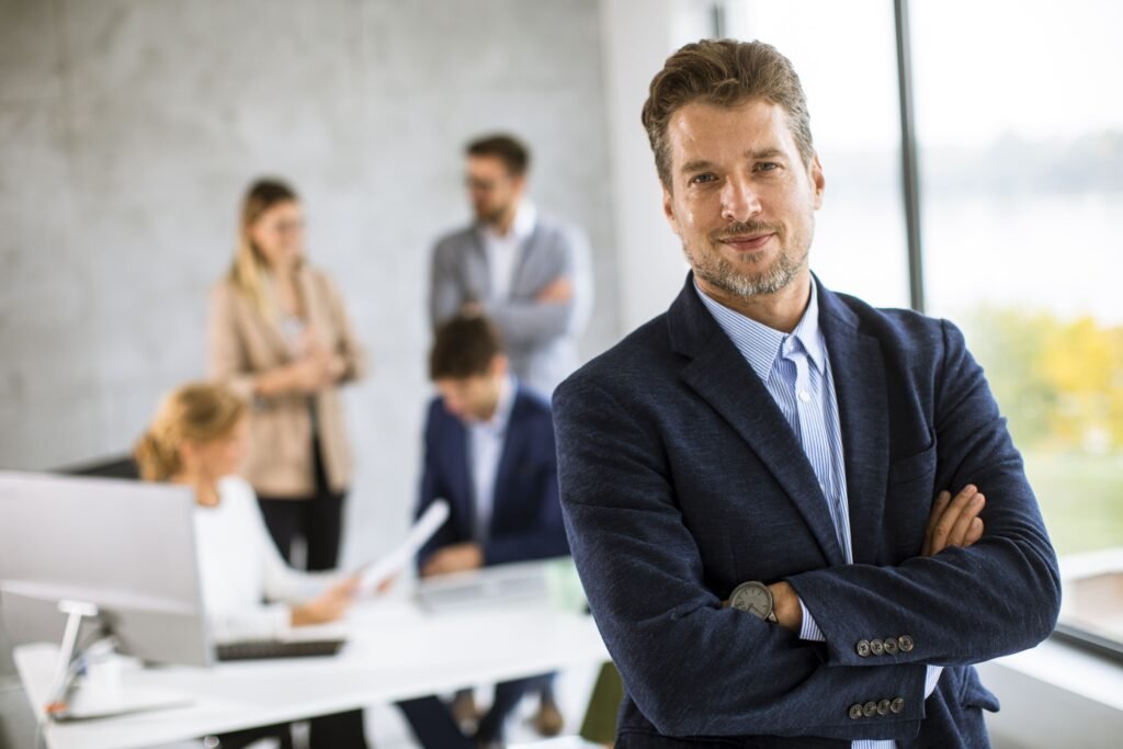 handsome-young-business-man-standing-confident-office-front-his-team (1)(1)(1)